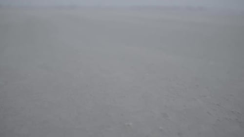 Slowmotion closeup of sand moving along the beach in the wind LOG