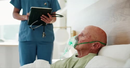 Senior Man in Hospital Bed with Oxygen Mask