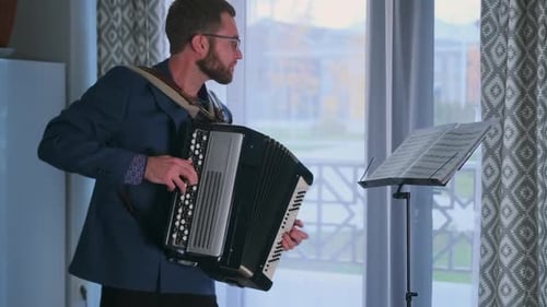 Jeune auteur-compositeur-interprète filmant le teaser d'une chanson originale pour accordéon à la maison