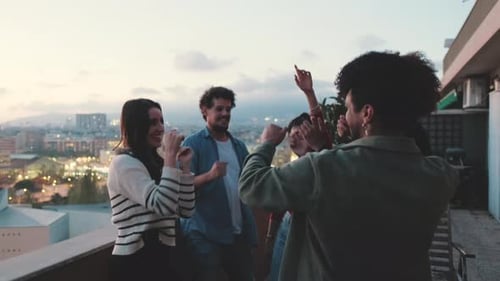 Friends Dancing on Rooftop at Sunset