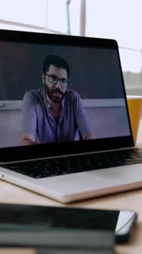 Unrecognizable Person Having a Virtual Conversation with Tutor on Laptop