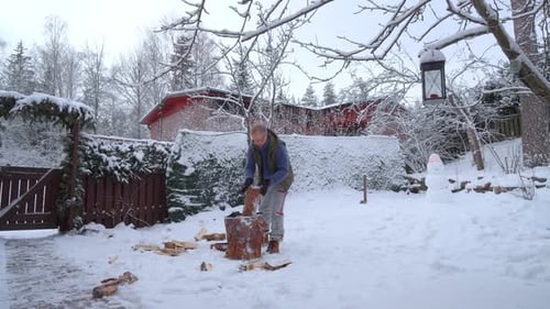 A Middleaged Man is Chopping Firewood