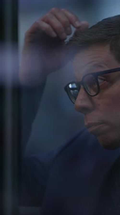 A Contemplative Man is Seen Behind a Glass Window Reflecting on Life and Moments Experienced