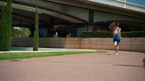 Woman Running in Urban Park on Sunny Day