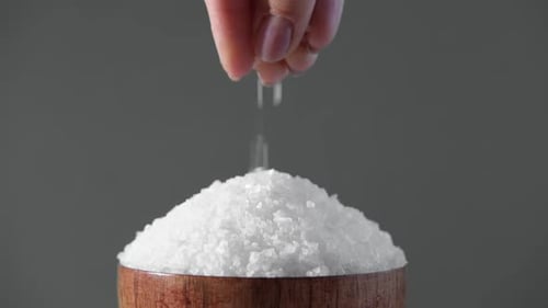 Female Hand Adding Salt Fingers Sprinkle White Table Salt Granules Into Pile Studio Background
