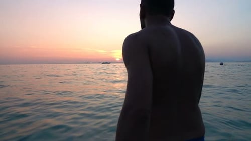 Silhouette Of Young Man Walking In The Sea During Sunset, Super Slow Motion