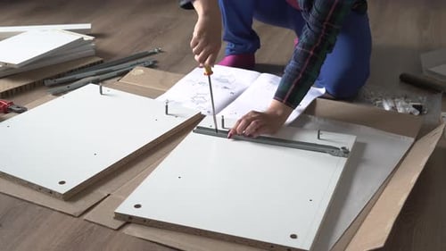 Woman Screwing Screw While Assembly Furniture