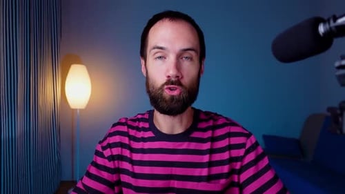 A Young Blogger Records a Video with Himself on His Phone in His Studio