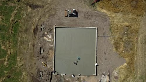 Aerial descent finish concrete work construction. Construction of rural farm agriculture building.