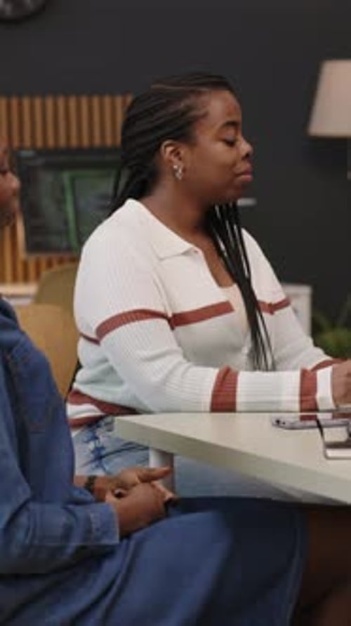 Une équipe de collègues afro-américains discute lors d'une réunion de bureau