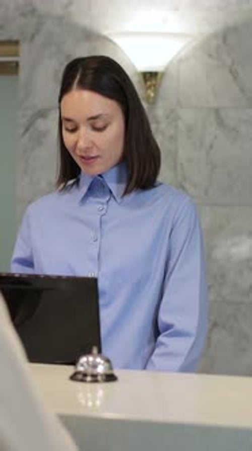 Vertical Video Administrator Giving Tourist Man Key Card at Hotel Desk Concierge Service Woman Smile