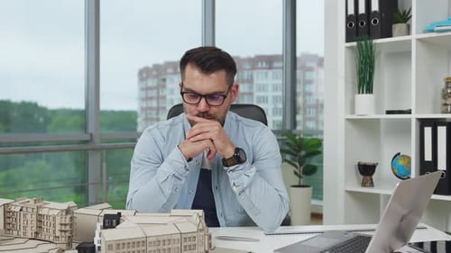 Man engineer brainstorming the versions about project of future buildings in modern design office