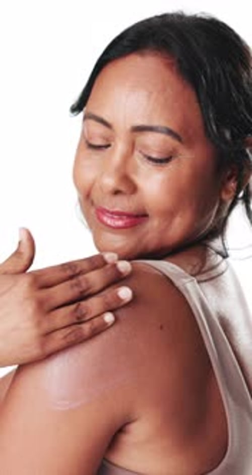 Happy woman, skincare and shoulder with cream in studio for moisturizer on a white background