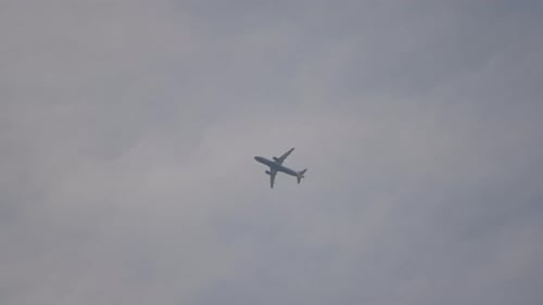 Passenger aircraft ascending up to cloudscape, view from ground