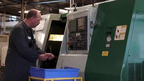 Senior machinist inspecting machinery repairing equipment in a machine shop