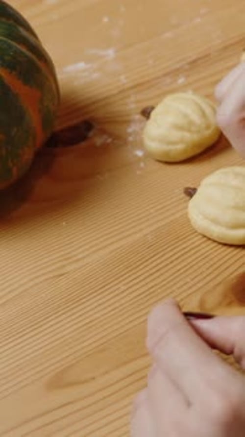 Shaping Holiday Cookies Dough into Pumpkins on Table