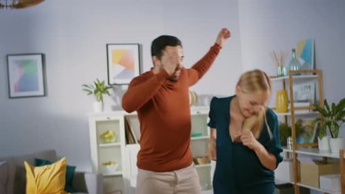 Happy Young Couple Dancing Together at Home