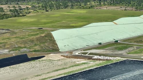 Aerial View of Landfill with Green Trucks
