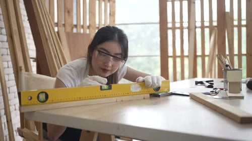 Carpenter is working at woodshop.