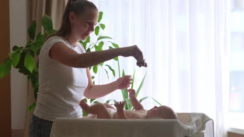Mother Playing with Happy Infant on Changing Table