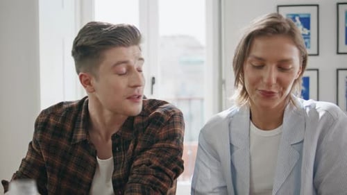 Young Adult Couple Drinking Coffee Together Indoors
