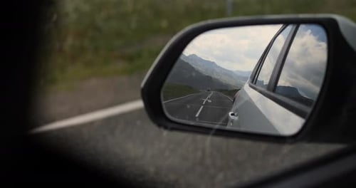 Bergstraße spiegelt sich während einer Panoramafahrt im Auto-Seitenspiegel