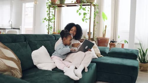 Woman and Child Using Laptop on Sofa Indoors