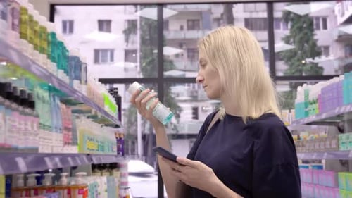 Purchase in cosmetics store Scanning QR code from bottle on smartphone,