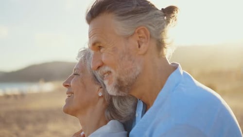 Mature married couple in love bonding outdoors at the beach