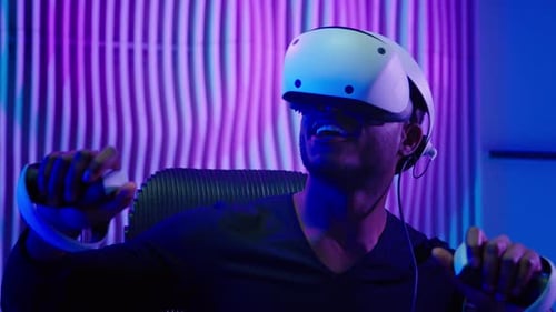 Young Adult Playing Video Game with VR Headset