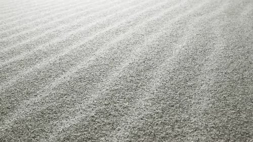 A Slow Motion Close Up View of Fine Shimmering Sand Grains Reflecting Light Creating a Sparkling