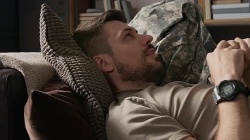 Man Lying on Sofa Wearing Military Uniform
