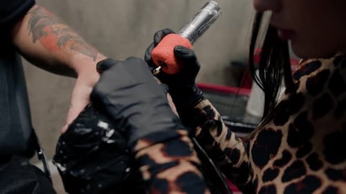 Close-up - a needle penetrates the skin, tattoo, tattoo studio