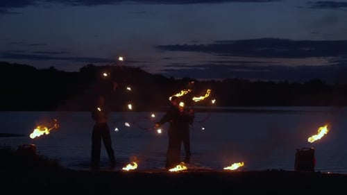 Circus Artists Performing Fire Show On River Coast In Summer Night Amazing Tricks With Flames