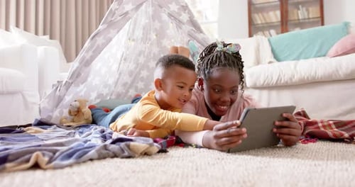 Children Using Tablet Together in Living Room Tent
