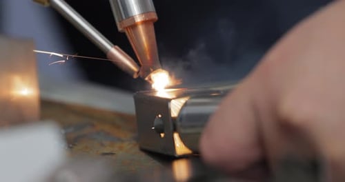 Laser welding machine with hand hold gun. Laser welding is shown in close-up.