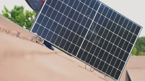 Technician carrying new solar panel to install on roof rails mount, static