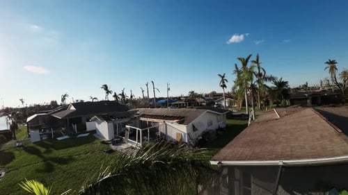 Drone shot flying over houses and trees destroyed and wrecked by storm