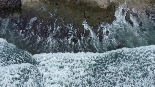 Die Wellen treffen auf die Felsen am Strand.