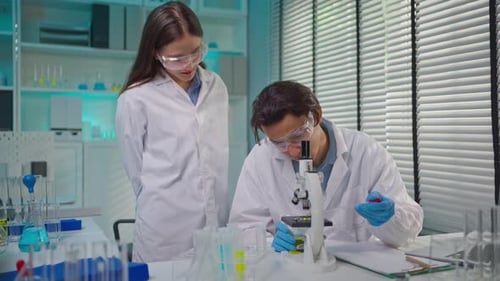 Scientists Working With Microscope in Laboratory