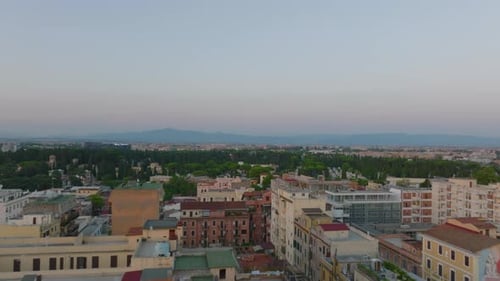 Vuelo bajo sobre edificios de apartamentos en la ciudad al anochecer