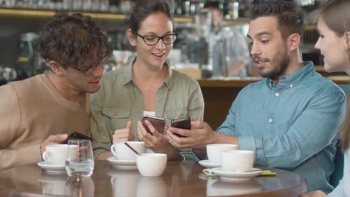 Group of Young Mixed race People using Phones in Coffee Shop.
