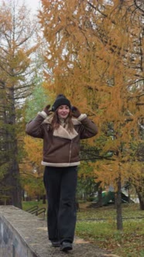 Student Balancing Joyfully on Stone Wall in Autumn Park