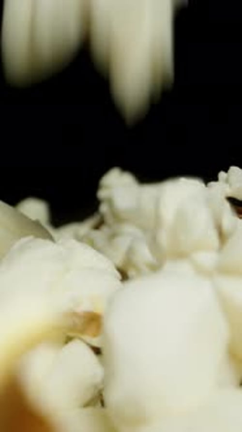 Vertical video. Close-up of falling popcorn background. Movement along the table covered.