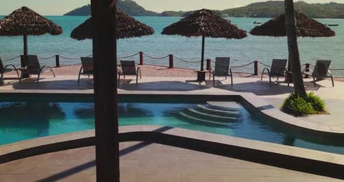 Luxury anonymous villa with swimming pool and sun beds with a scenic view to the ocean and exotic