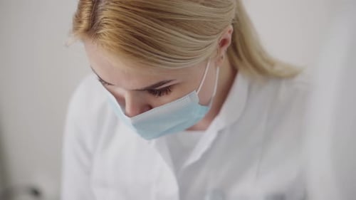 Blonde Adult Wearing a Mask in a Clinical Setting