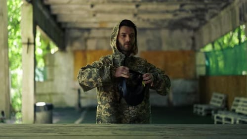 in der Wildnis im Hangar für Anweisungen: Ein Pintball-Coach zieht eine Uniform an, bevor das Spiel voll ist