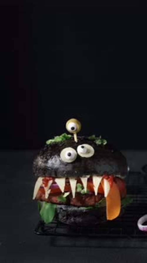 Festive Black Burger with Googly Eyes and Teeth