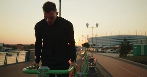 Young Athlete Working Out Doing Triceps Dips on a Street Sports Ground at Sunset