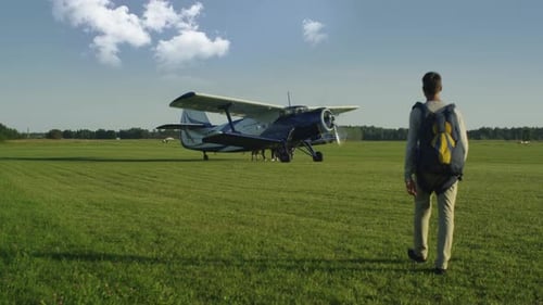 Paraquedista está se movendo em direção a um avião a hélice